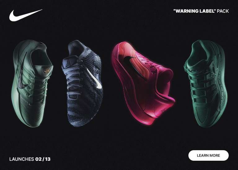 A promotional banner for the Nike Warning Label Pack featuring four different basketball shoe silhouettes displayed in a row against a dark background. The sneakers are bathed in dramatic, moody lighting in shades of muted green, deep blue, vibrant pink, and forest green, with a launch date of February 13th.