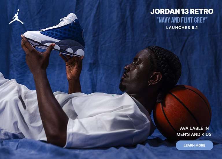 Jordan 13 Retro Navy and Flint Grey sneaker held above a basketball, available in men's and kids' sizes.