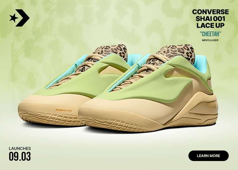 Pair of Converse SHAI 001 Cheetah basketball shoes in light green and cream with cheetah-print tongues and blue lining, displayed against a soft green background.