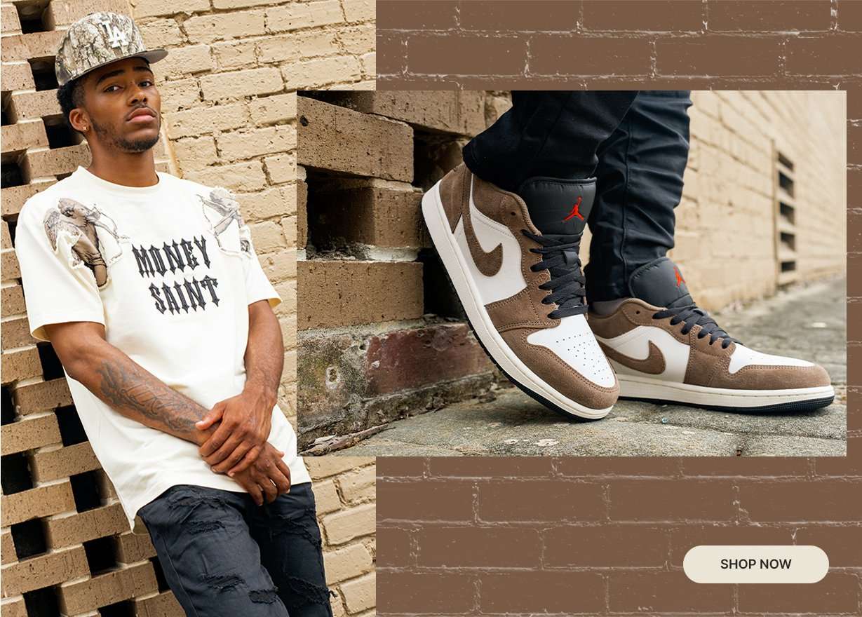 Person wearing a cream graphic tee, black denim, and brown-and-sail Air Jordan 1 sneakers posed against a brick wall, with a close-up of the sneakers featured alongside.