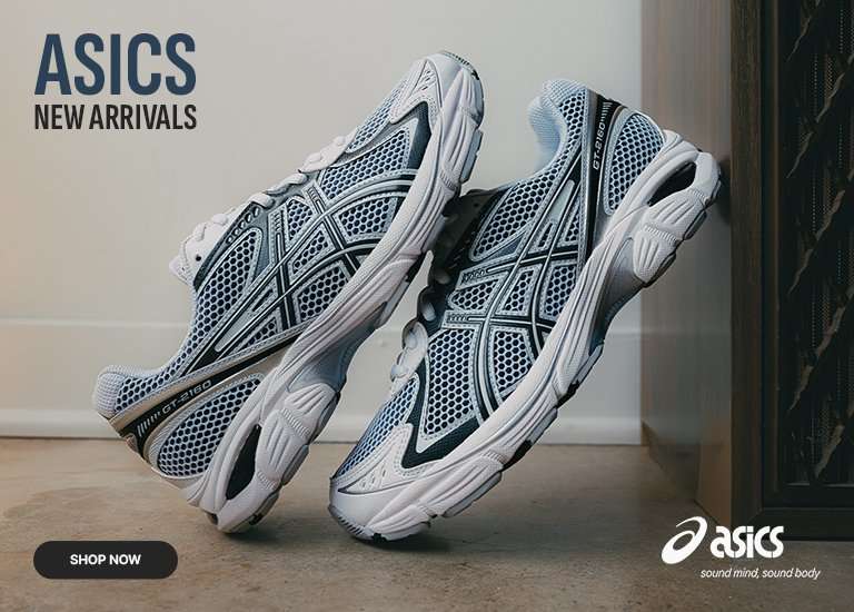 Promotional banner for Asics New Arrivals featuring two white and silver GT-2160 sneakers resting on a floor in front of a large speaker. The top left displays the text ASICS NEW ARRIVALS, the top right shows the Asics logo, and a Shop Now button is located in the bottom left corner.