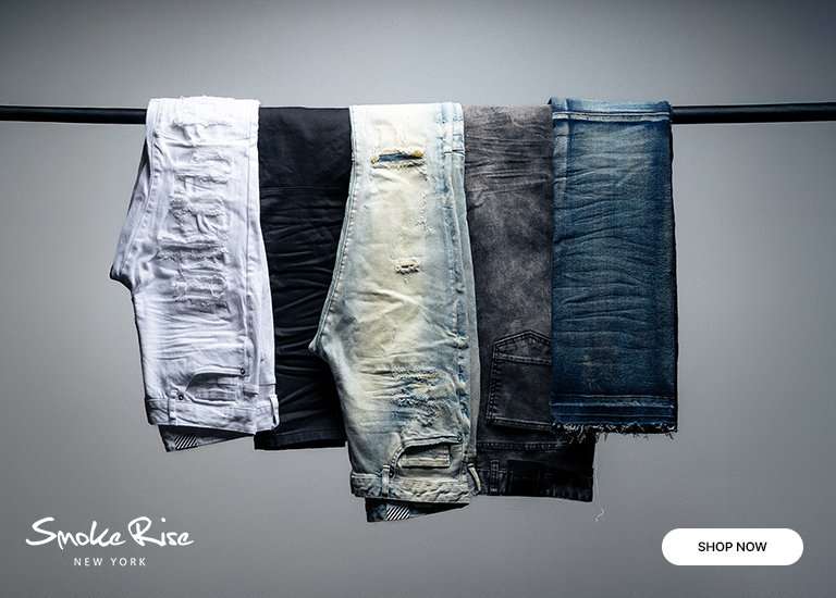 Promotional banner for Smoke Rise New York featuring five pairs of men's jeans in various washes (white, black, light blue, grey, and dark blue) hanging over a black bar, with a Shop Now button in the bottom right corner.