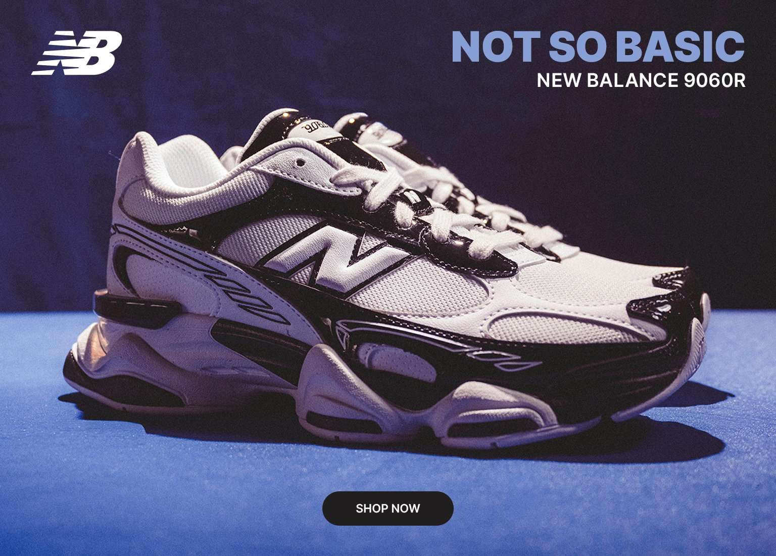 New Balance 9060R sneaker in white and black, showcased against a bold blue backdrop with a modern, high-contrast look.