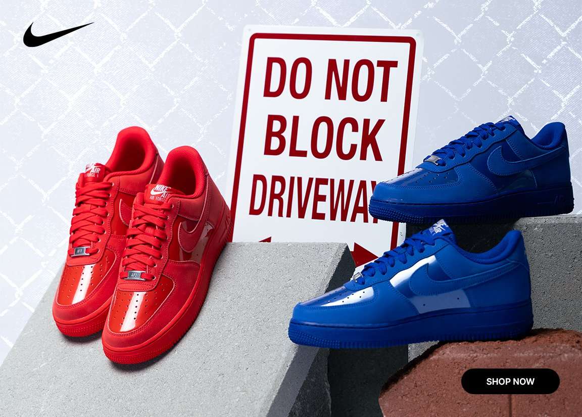 Nike Air Force 1 sneakers in bold red and blue colorways displayed on concrete blocks beside a Do Not Block Driveway sign.