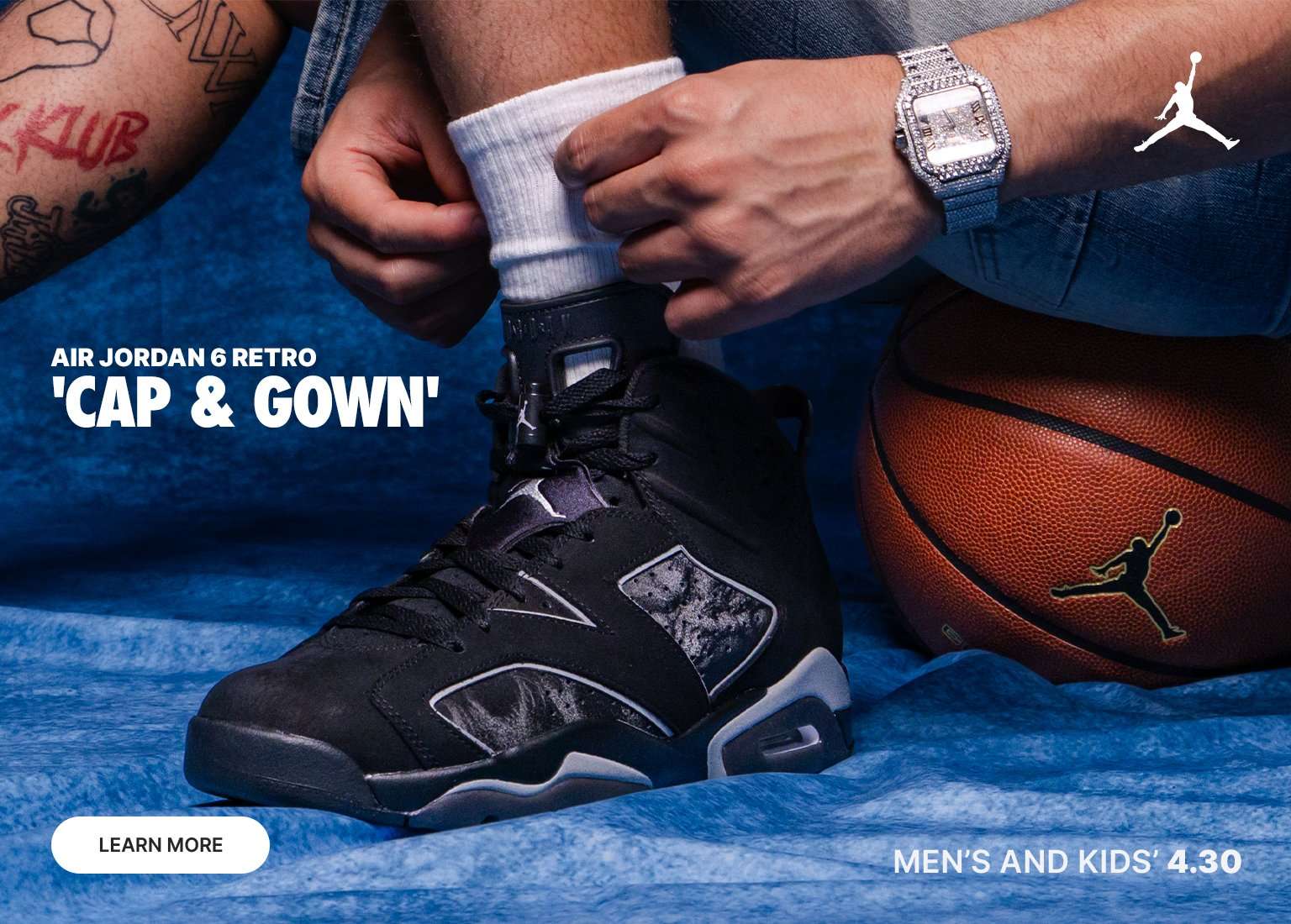 A man in a graduation cap and denim shorts sits on a stool, tossing a basketball against a blue backdrop. The collage features close-ups of the black Air Jordan 6 Retro 'Cap and Gown' sneakers, a graduation gown with a 2026 tassel, and a Jordan-branded basketball. Text indicates a release date of 4.30 for men’s and kids’ sizes. 