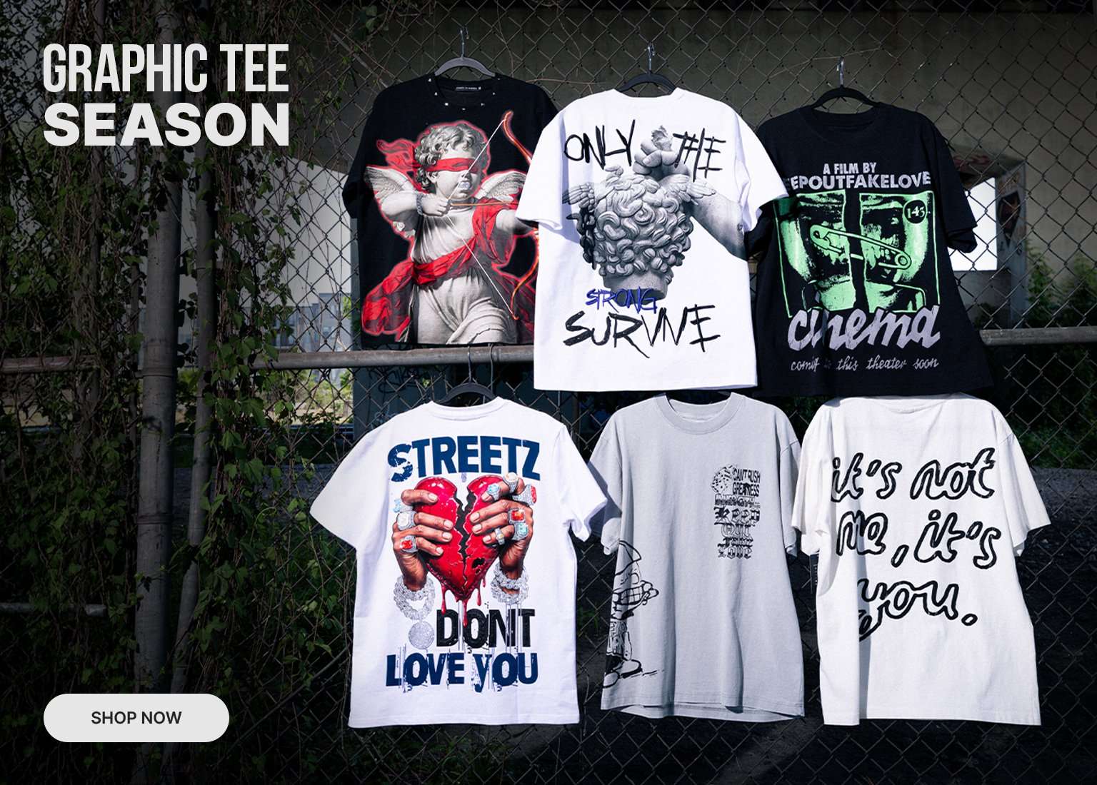 Graphic tee season featuring six graphic t-shirts displayed on a chain-link fence with shop now button.