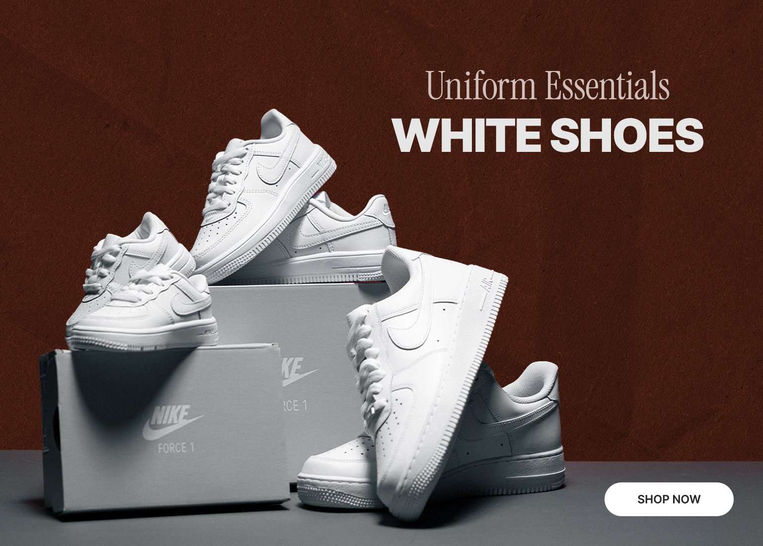 White Nike Air Force 1 sneakers displayed on shoeboxes with Uniform Essentials White Shoes text.