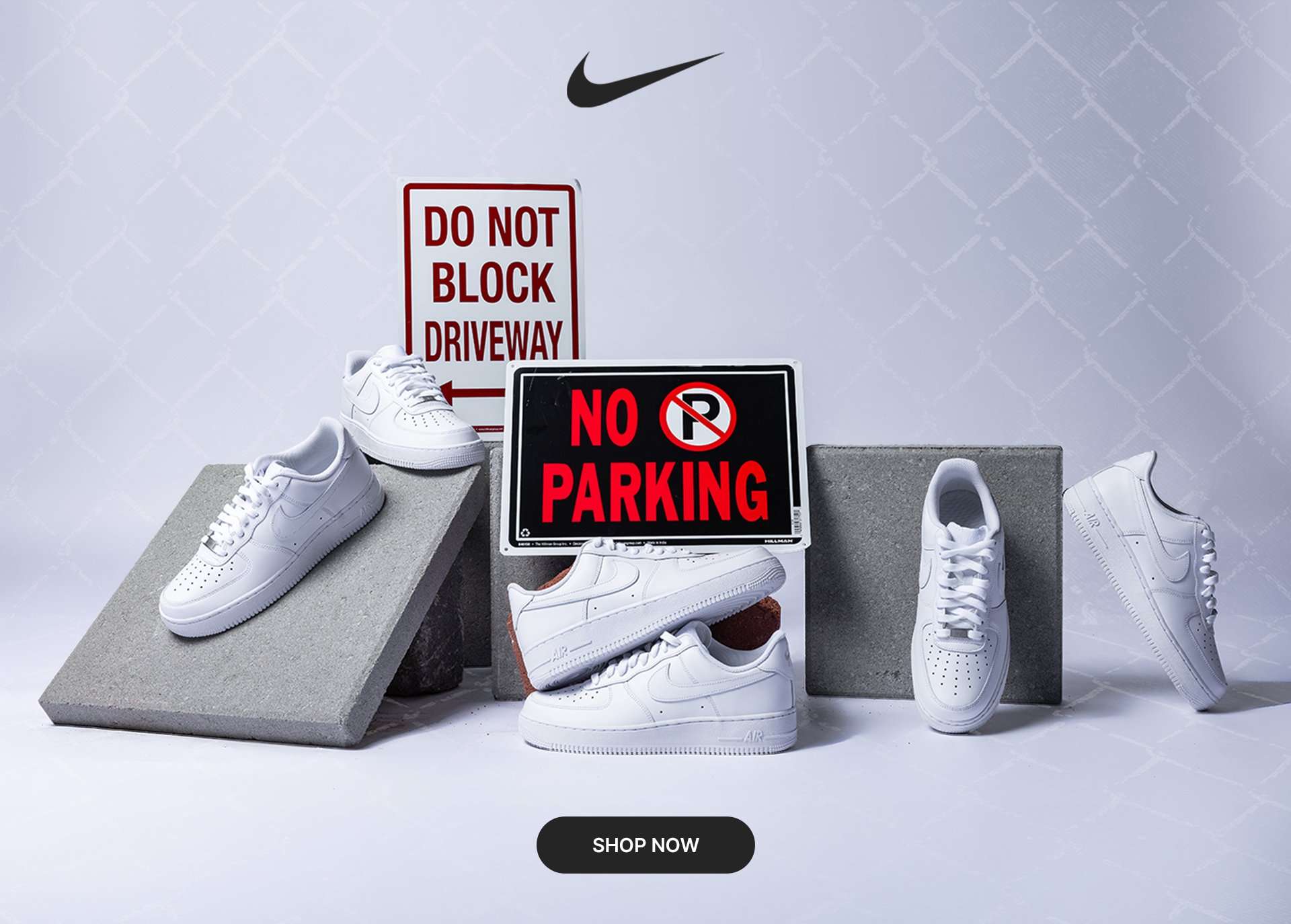 Nike Air Force 1 '07 Triple White sneakers displayed on concrete blocks with street signs reading Do Not Block Driveway and No Parking. Multiple views of the all-white shoes are shown against a light gray background with a Shop Now button.