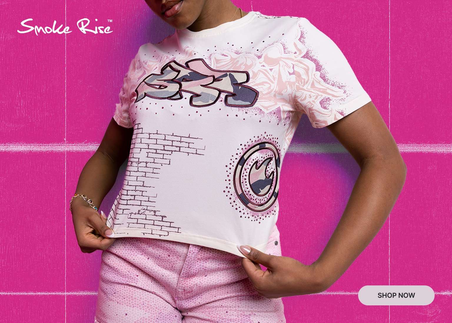 Smoke Rise banner featuring a model in a white graphic tee with pink detailing and matching pink pants against a bright pink background, with a Shop Now button.