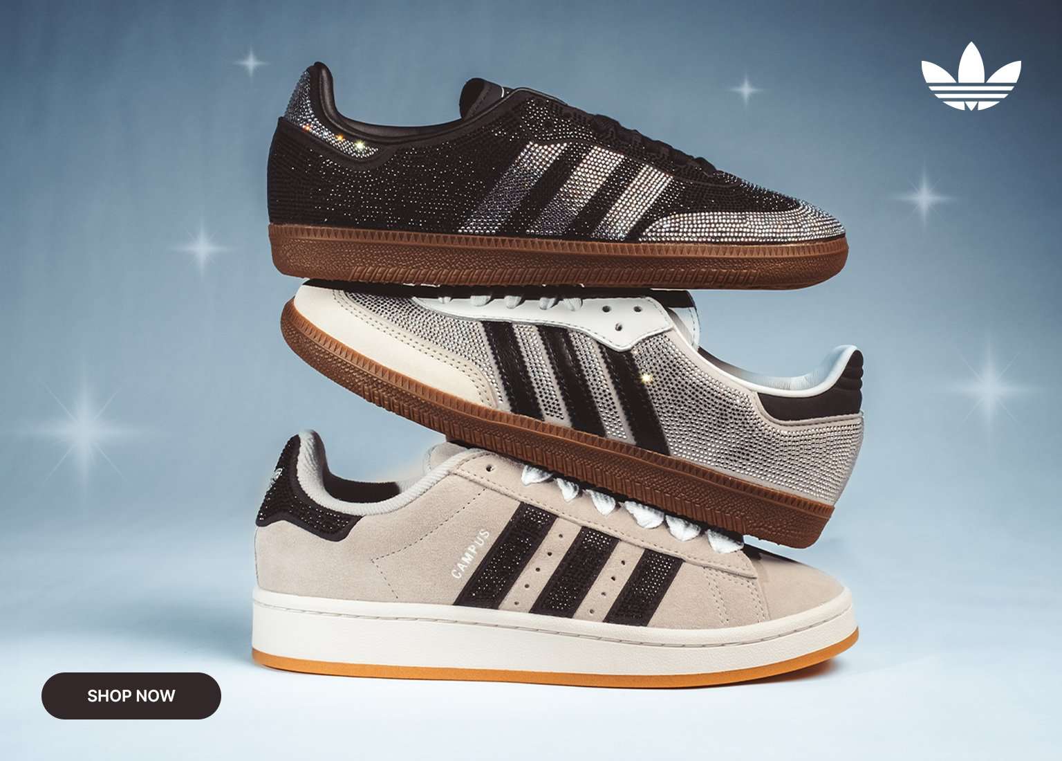 Three adidas sneakers stacked vertically in black, silver, and beige colorways with rhinestone detailing on a blue background.