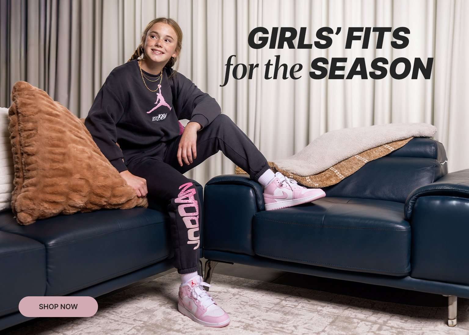 Girl lounging on a sofa in a pink-and-black Jordan outfit with matching sneakers, next to text reading ‘Girls’ Fits for the Season.’