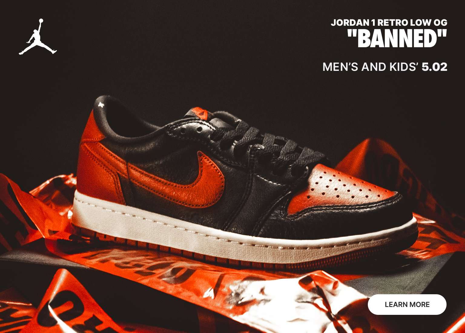 A promotional banner for the Air Jordan 1 Retro Low OG Banned sneakers. The image features a low-top sneaker in a black and red Bred colorway with a white midsole, resting on red caution tape. Text includes the Jordan Jumpman logo, the product name, Men's and Kids' 5.02, and a Learn More button.