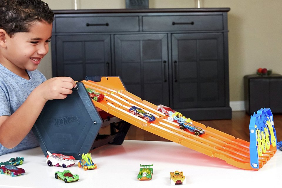Boy playing with the Hot Wheels Roll Out Raceway Track Set and Cars.