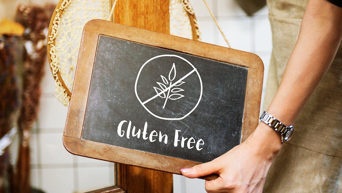 Person holding a chalkboard with the words Gluten Free.