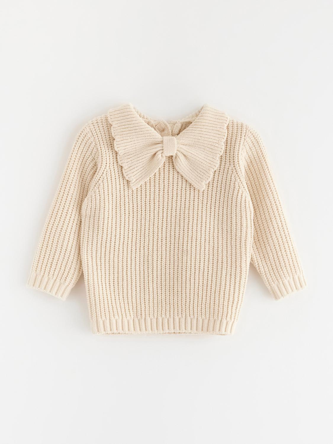 Stickad tröja med rosett