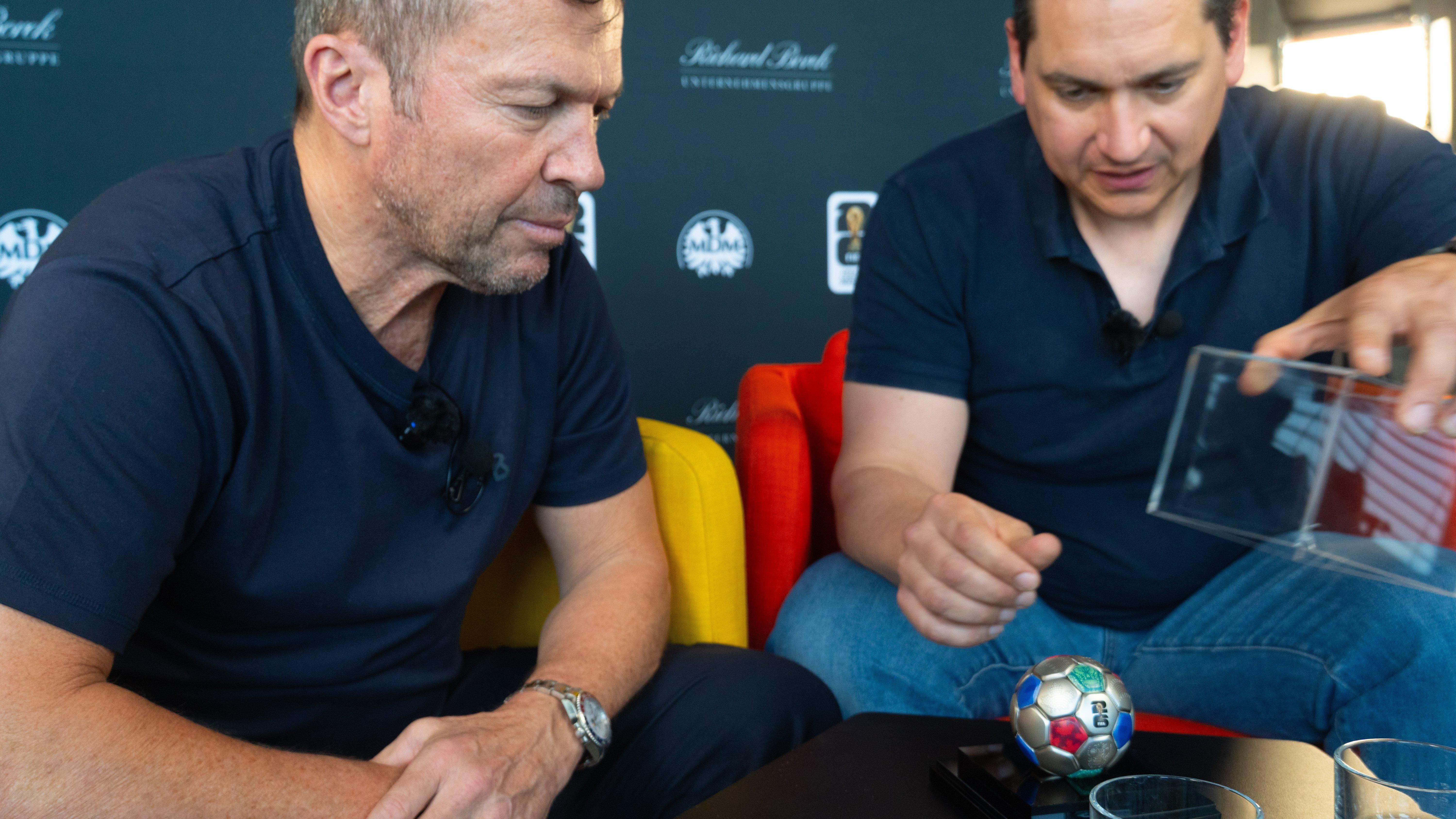 Lothar Matthäus am Tisch mit der 3D-Silbermünze in Fußball-Form
