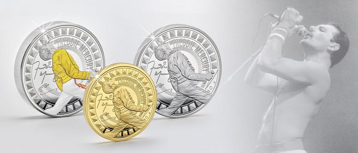Gedenkmünzen mit Freddie Mercury in Silber, Farbe und Gold, daneben ein Konzertfoto des Sängers im Hintergrund