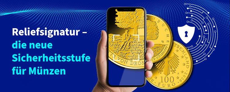 Reliefsignatur als neue Sicherheitsstufe für Münzen, gezeigt per Smartphone-Scan und Goldmünzen im Hintergrund.