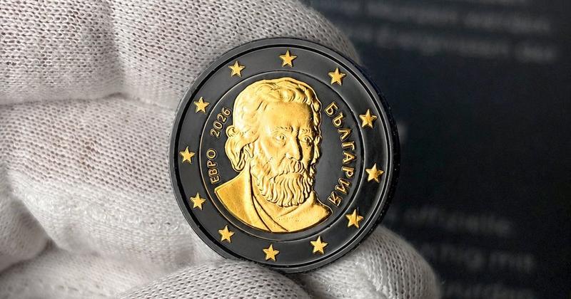 Hand mit Stoffhandschuh, die eine veredelte 2-Euro-M&uuml;nze h&auml;lt