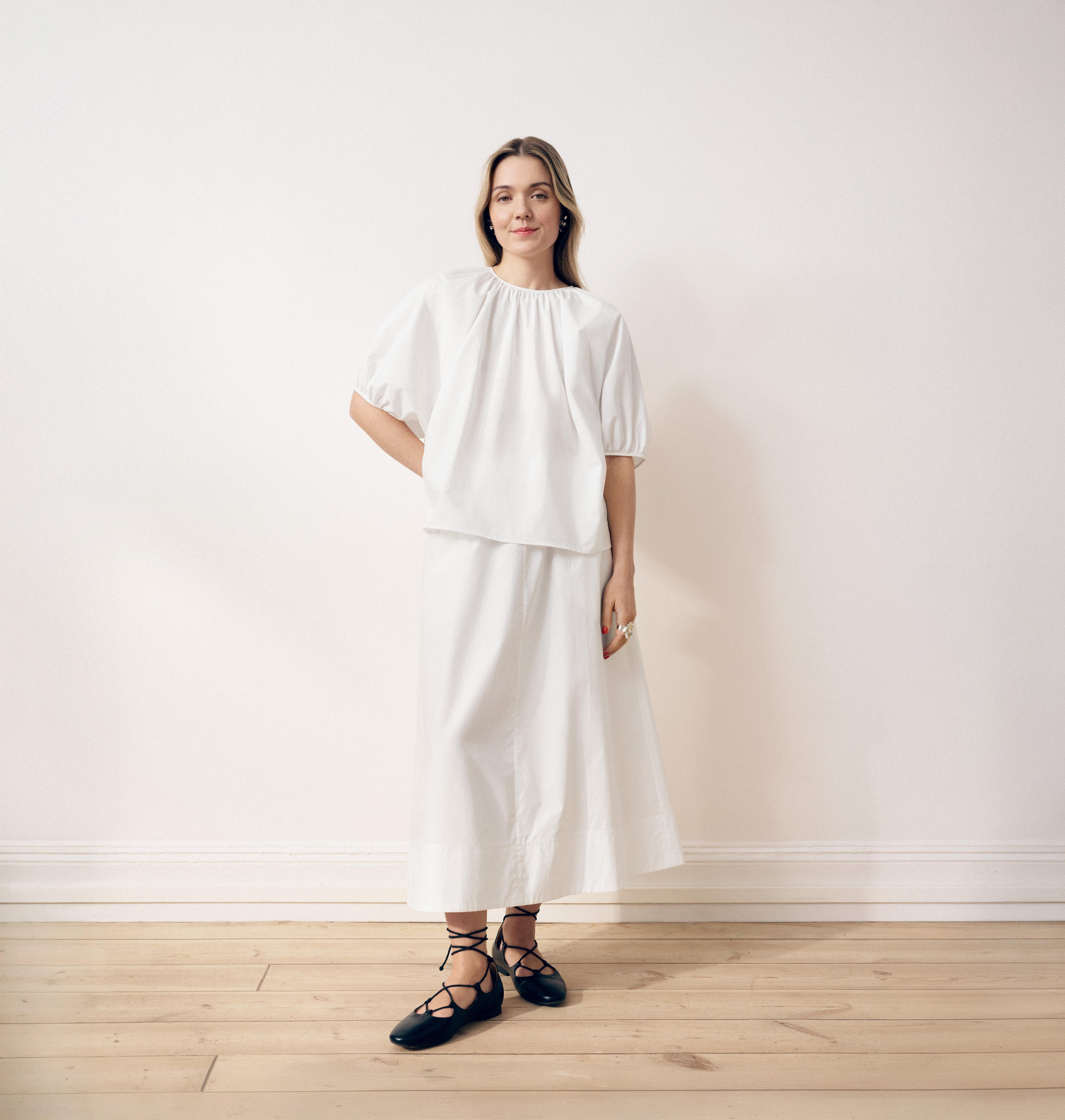 modell med vit kjol och vit blus