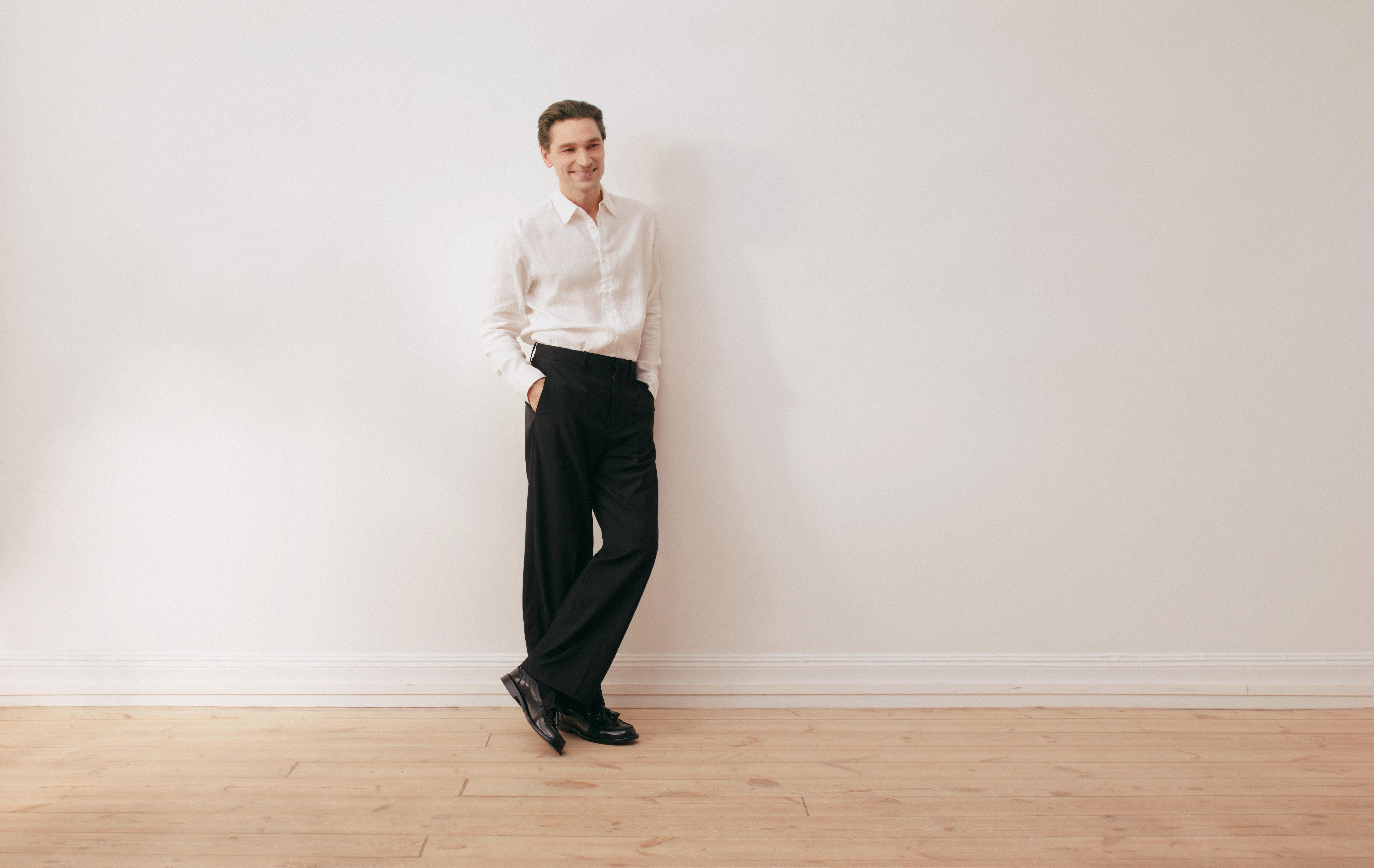 herrmodell med vit skjorta och svarta byxor