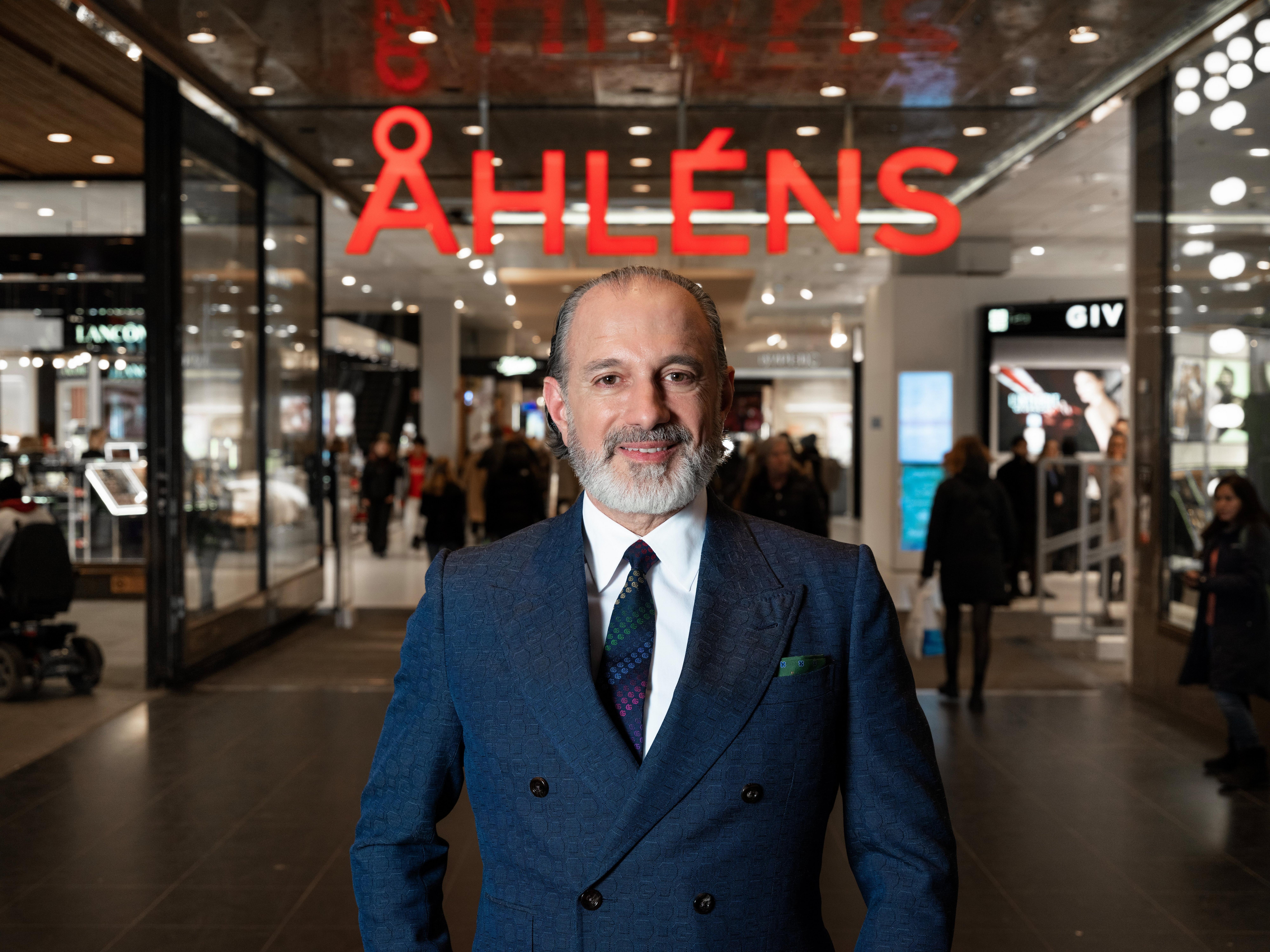 Ayad Al-Saffar i mörkblå kostym står vid entrén till ett av varuhusen.