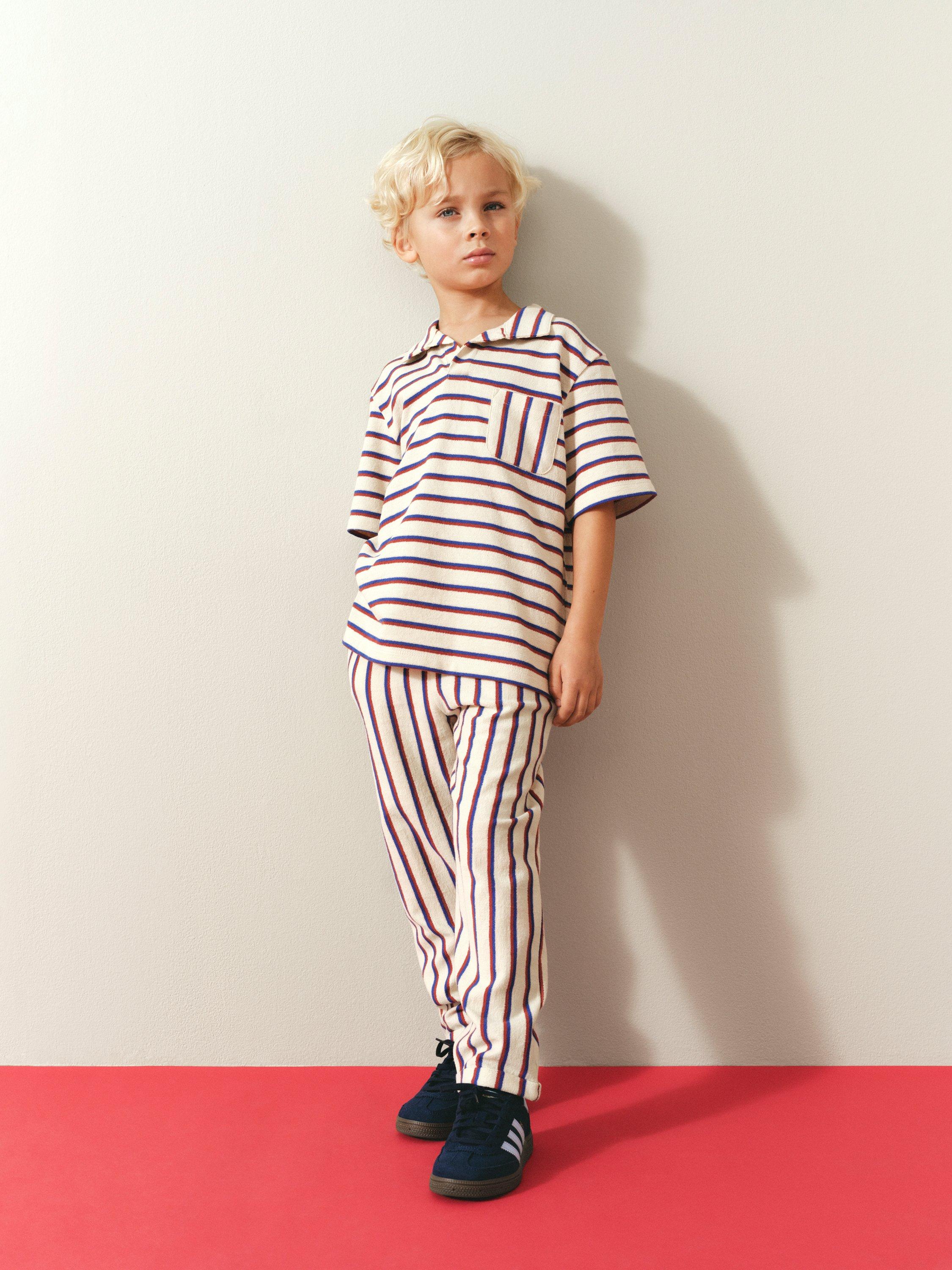 barn i kjol och tröja mot en blå bakgrund.