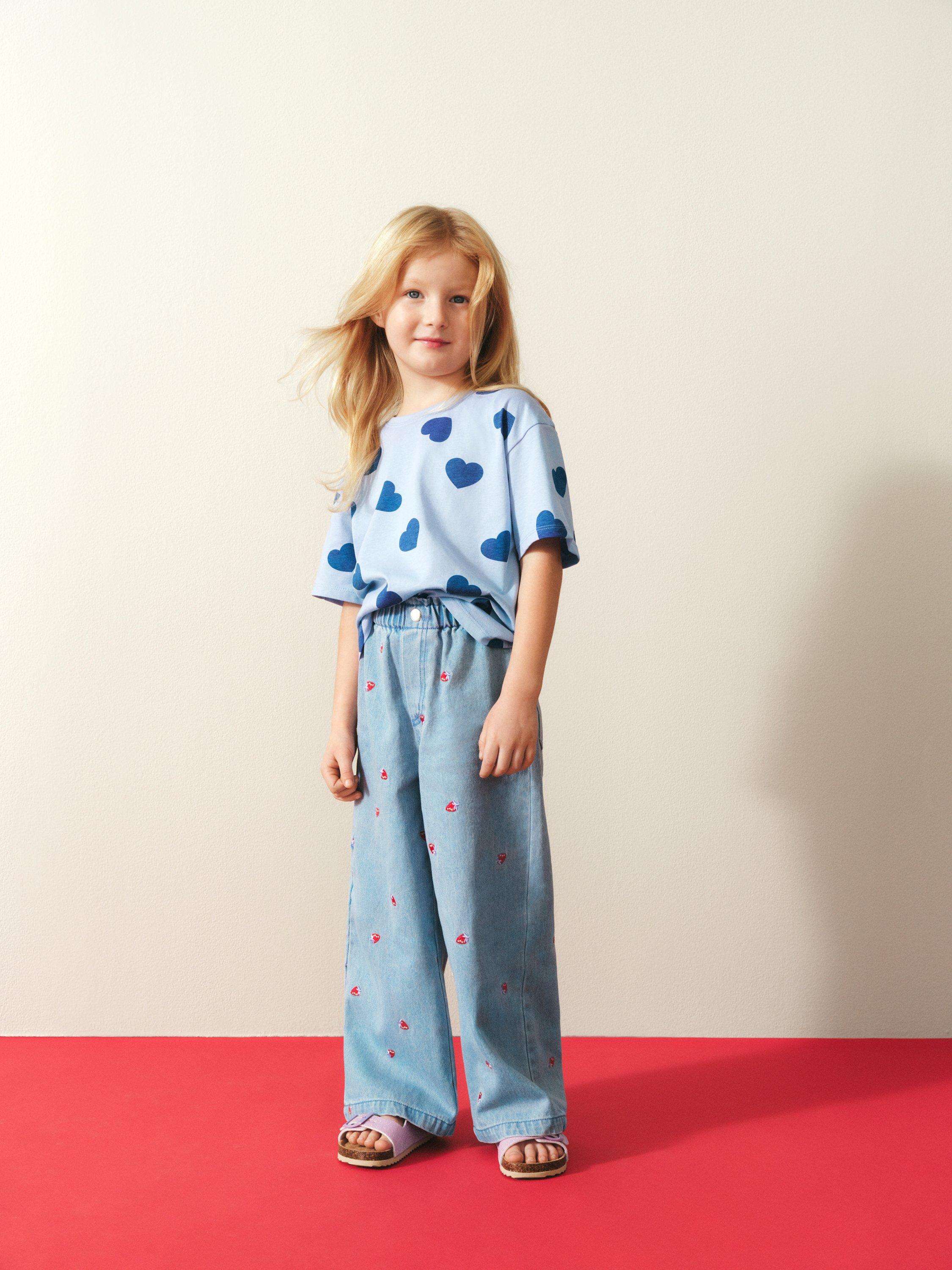 Barn med kläder omt lila bakgrund