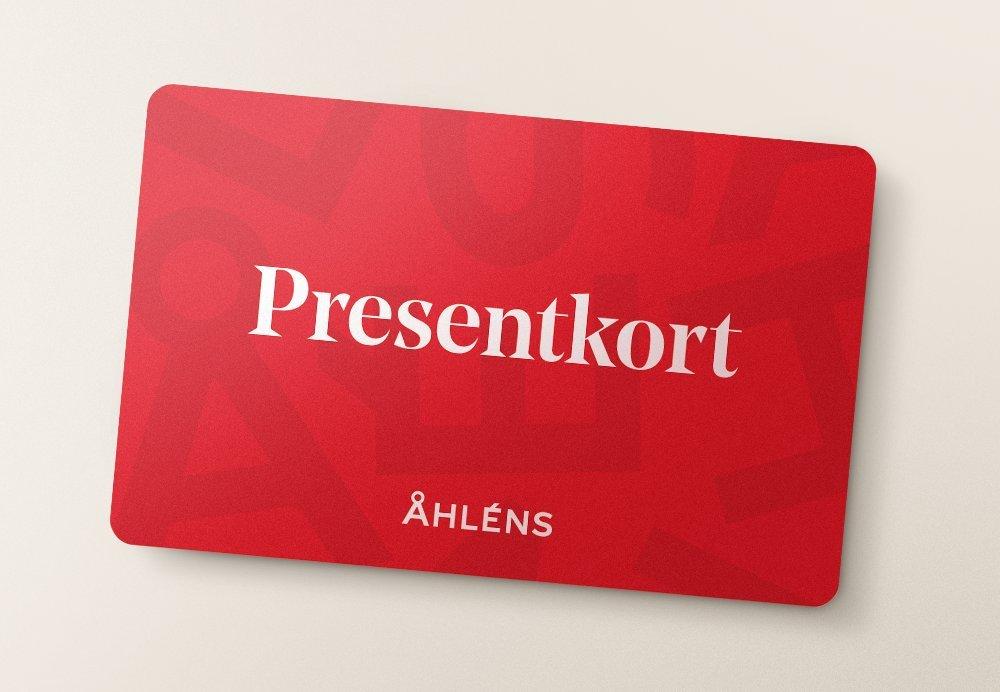 Rött presentkort från Åhléns med vit text och diskret ton-i-ton-mönster i bakgrunden.
