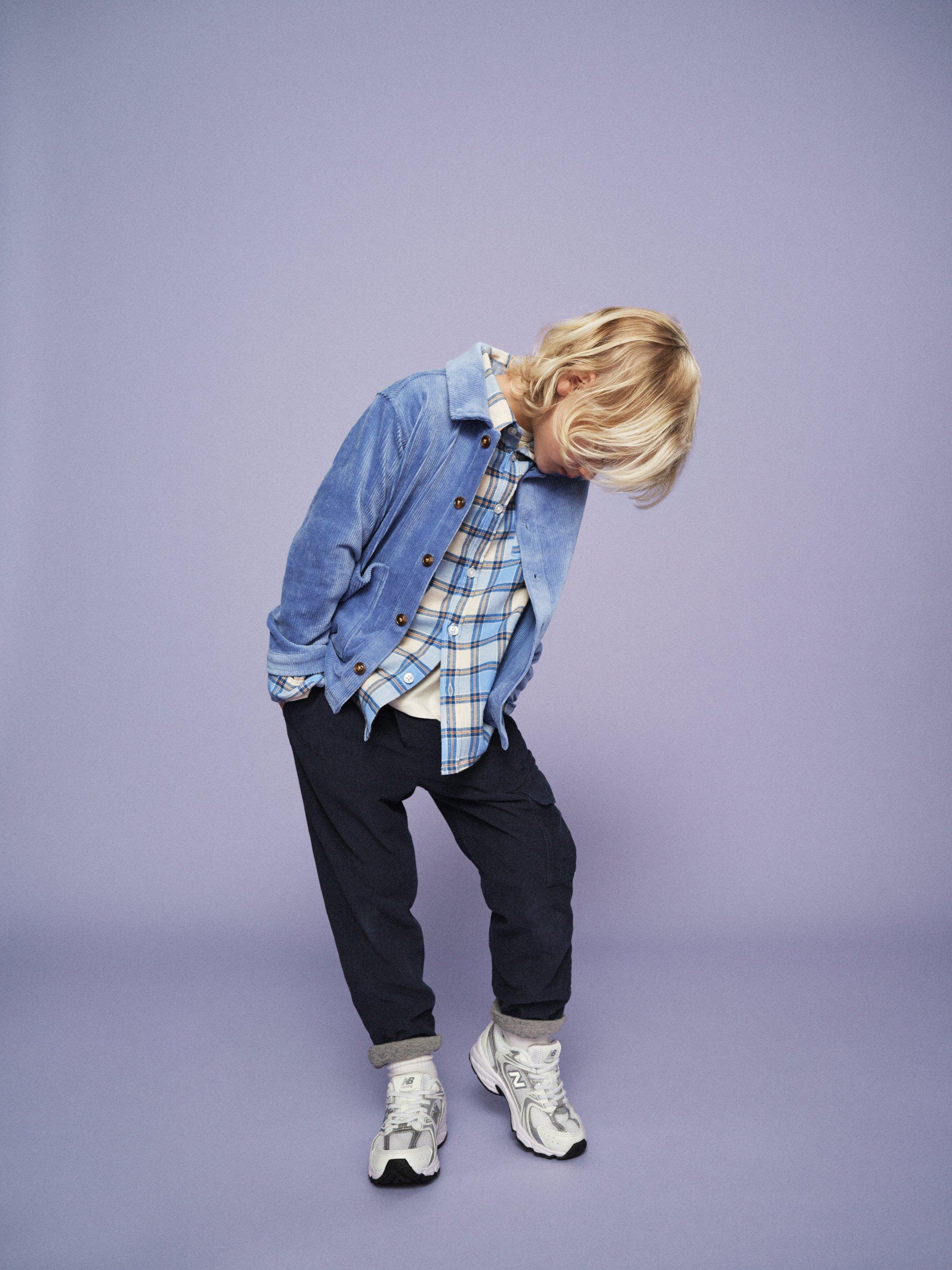 Barn med kläder omt lila bakgrund