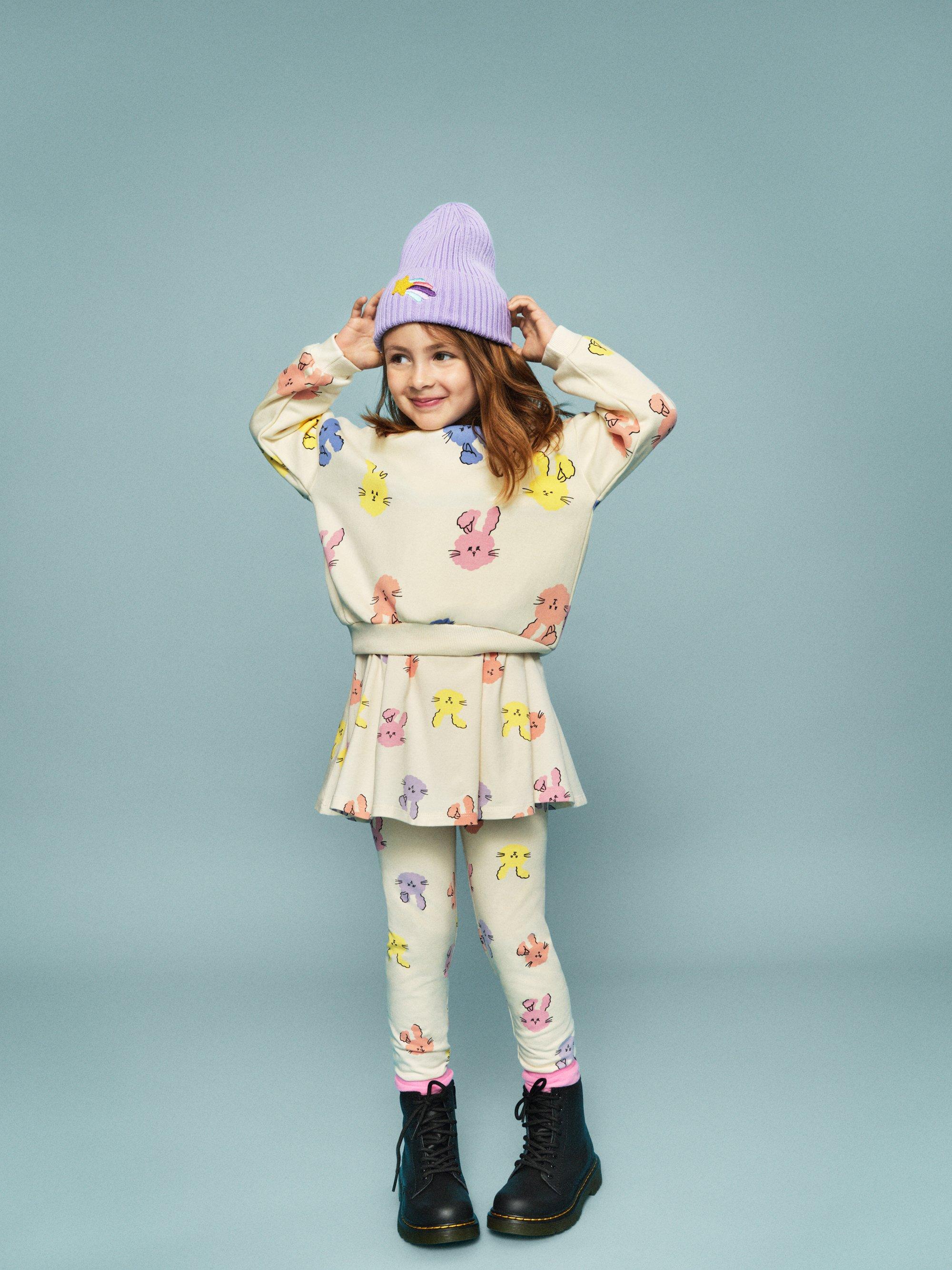 barn i kjol och tröja mot en blå bakgrund.