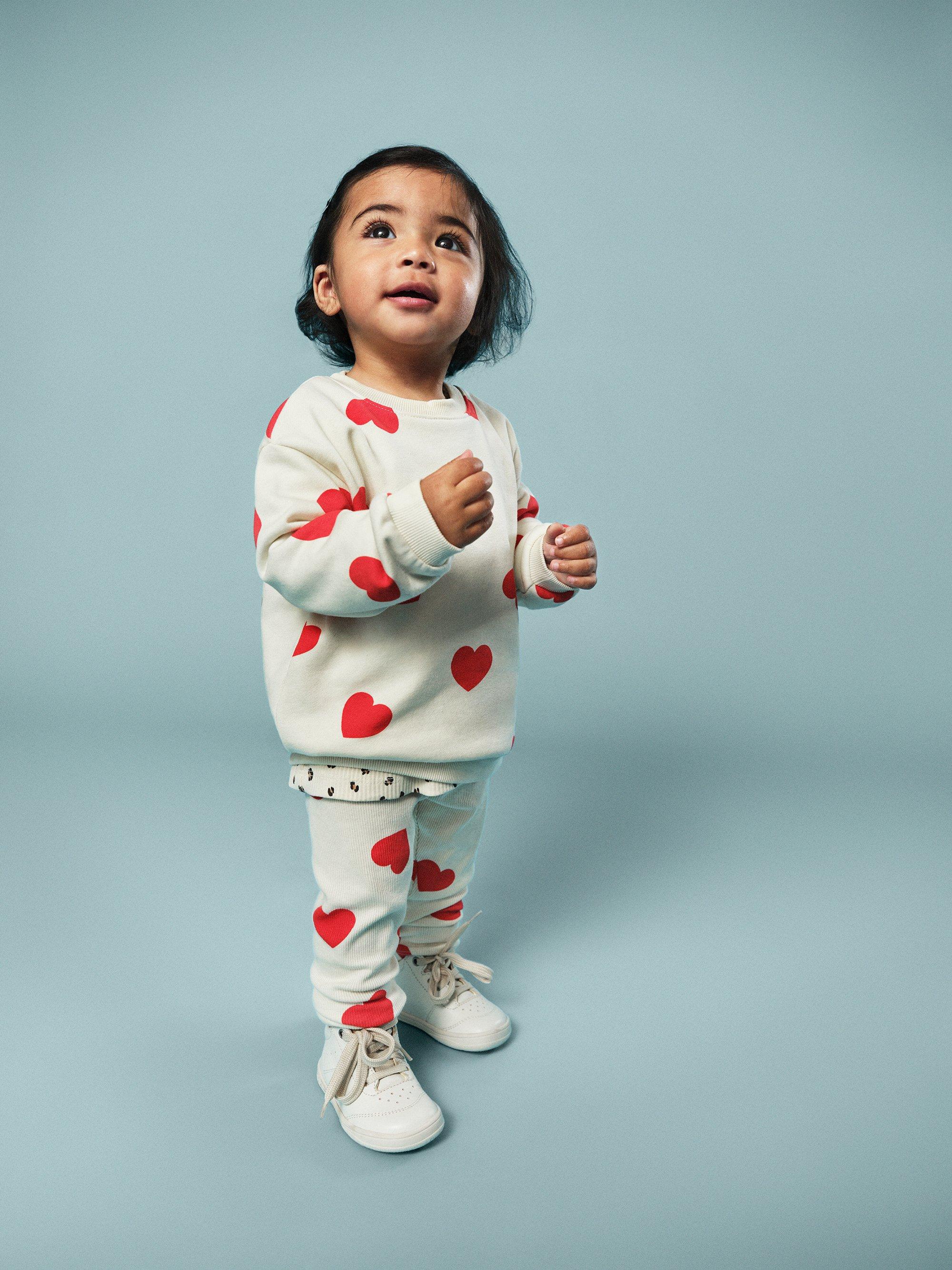 baby i hängselbyxor och blå bakgrund