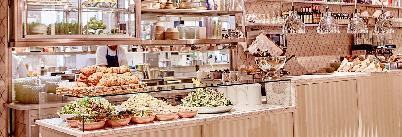 Buffé med sallader och bröd i öppen restaurangmiljö hos Sally Voltaire & Systrar.