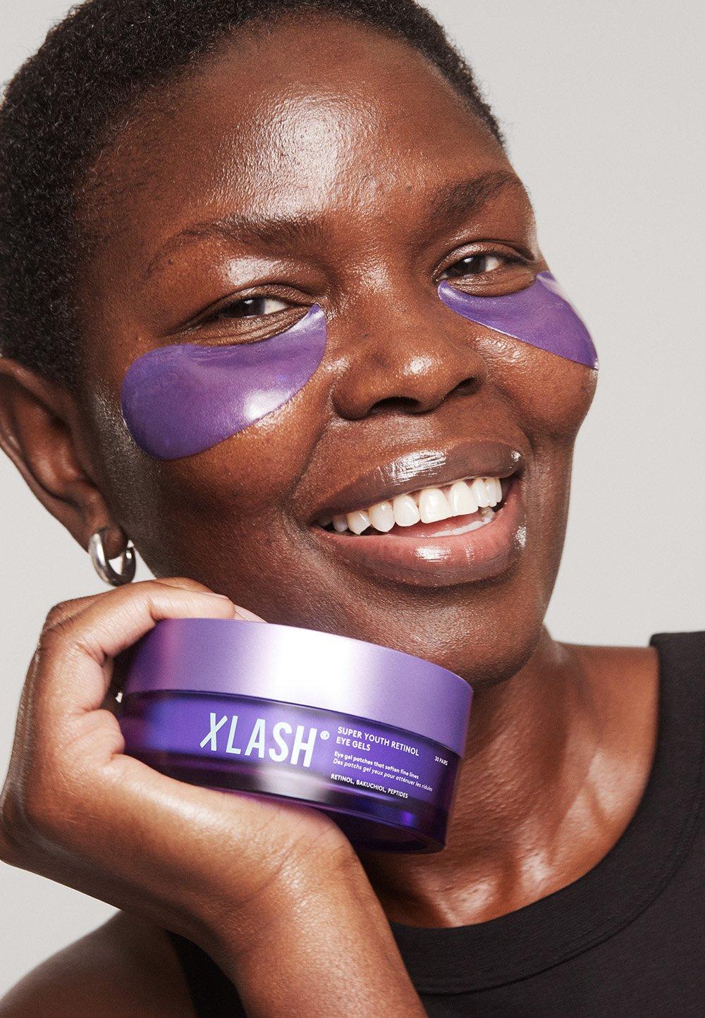 Leende kvinna med lila eye gels under ögonen