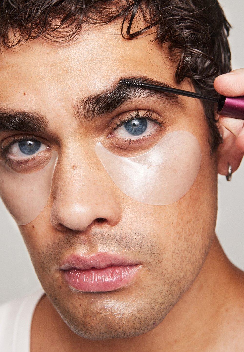 Man med blåa ögon använder ögonbrynsgele