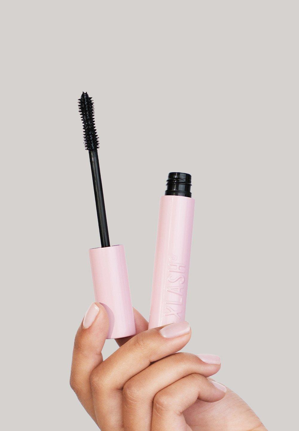 Hand håller i en mascara i rosa förpackning