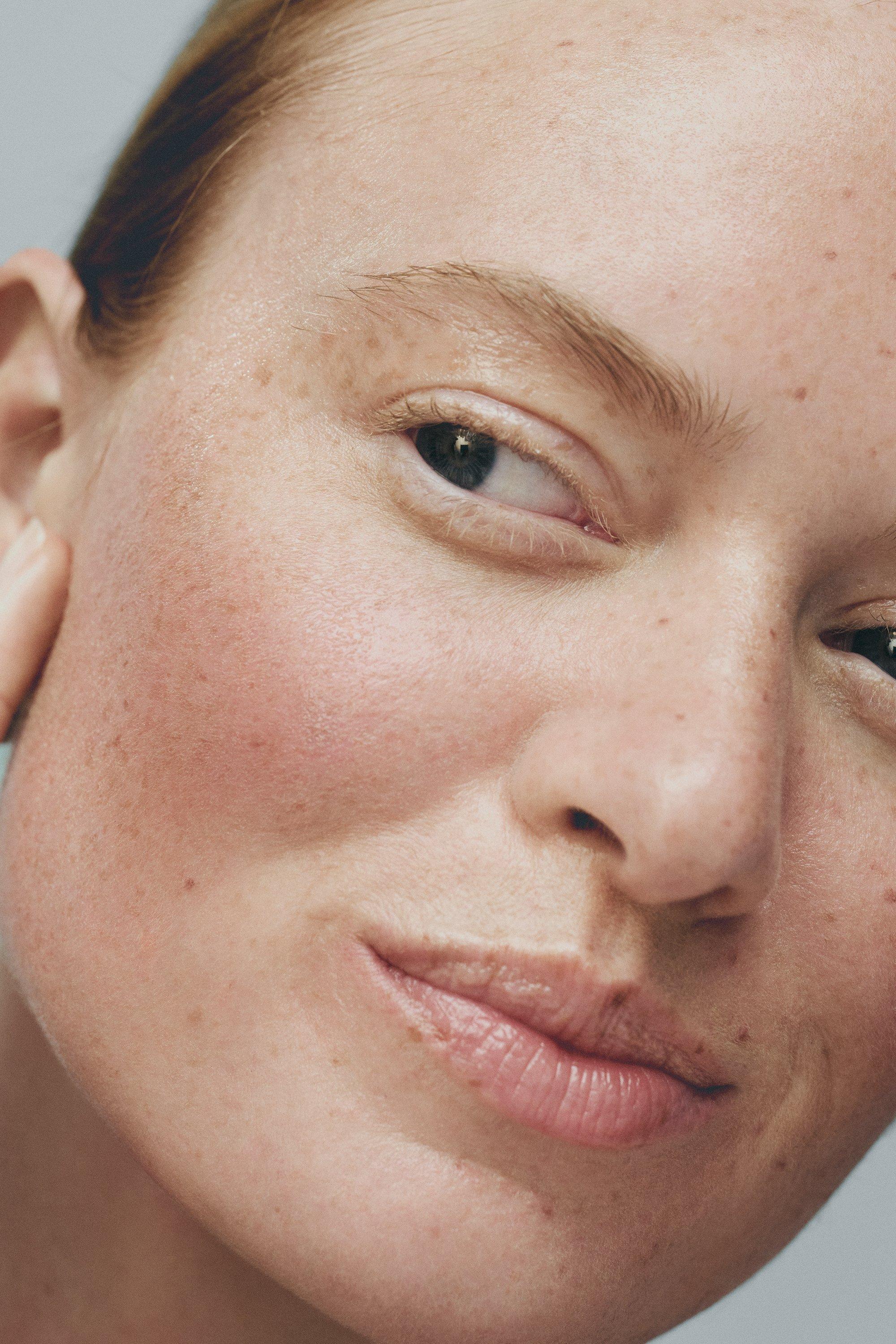 Kvinna smörjer in ansiktet med serum