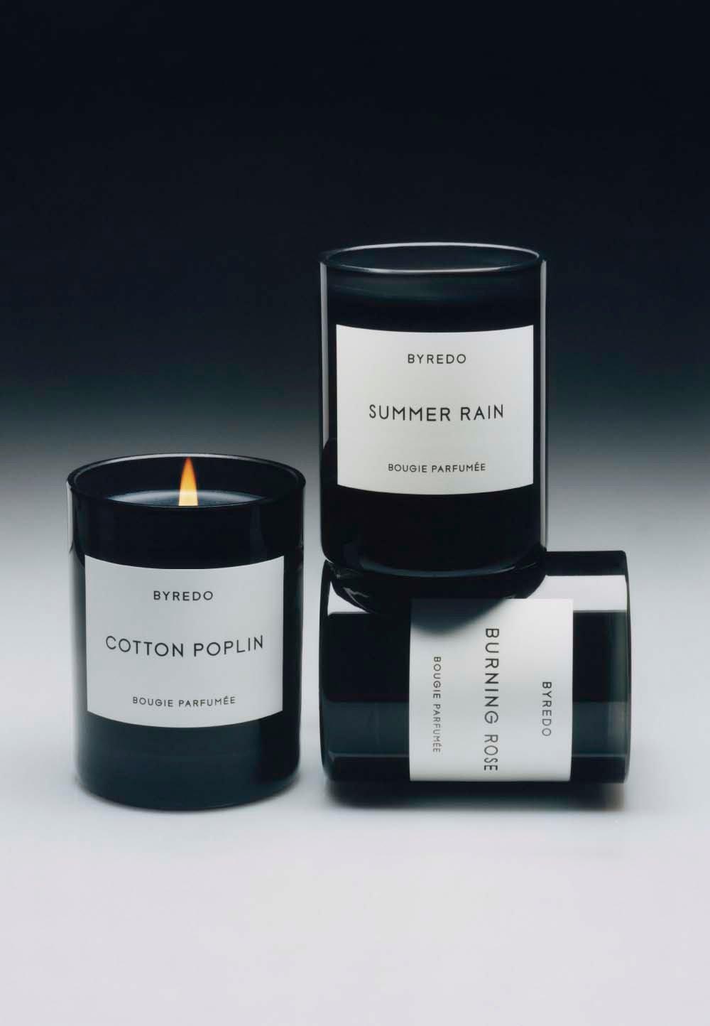 3 doftljus står på varandra mot en svart bakgrund