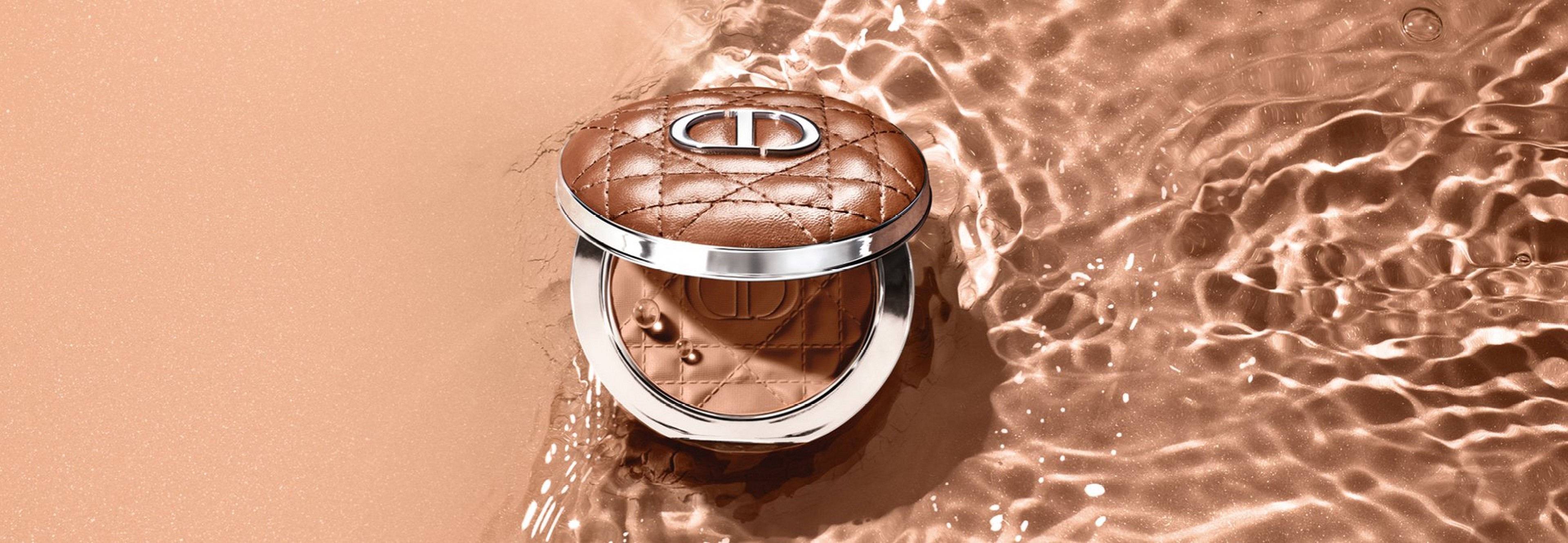 Bronzer från Dior ligger på sandstrand vid vattnet