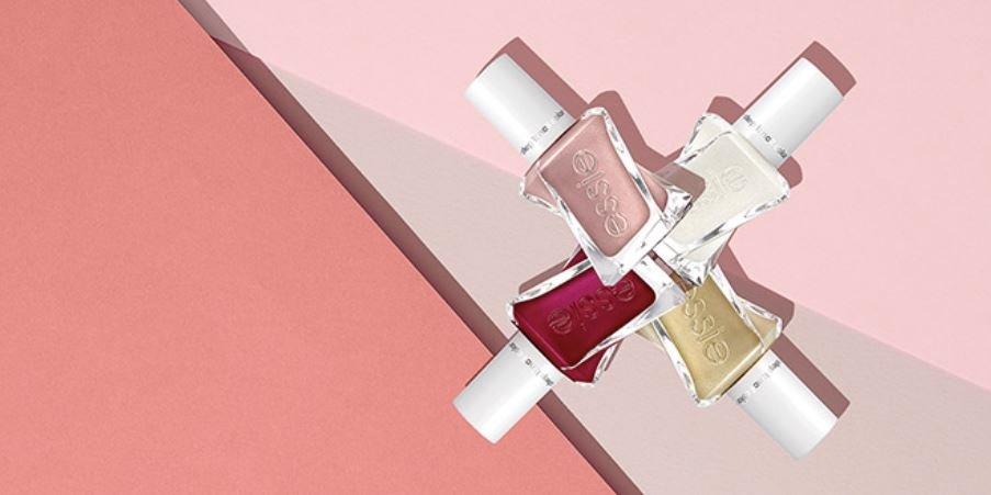 Fyra nagellack i olika nyanser arrangerade mot rosa bakgrund.