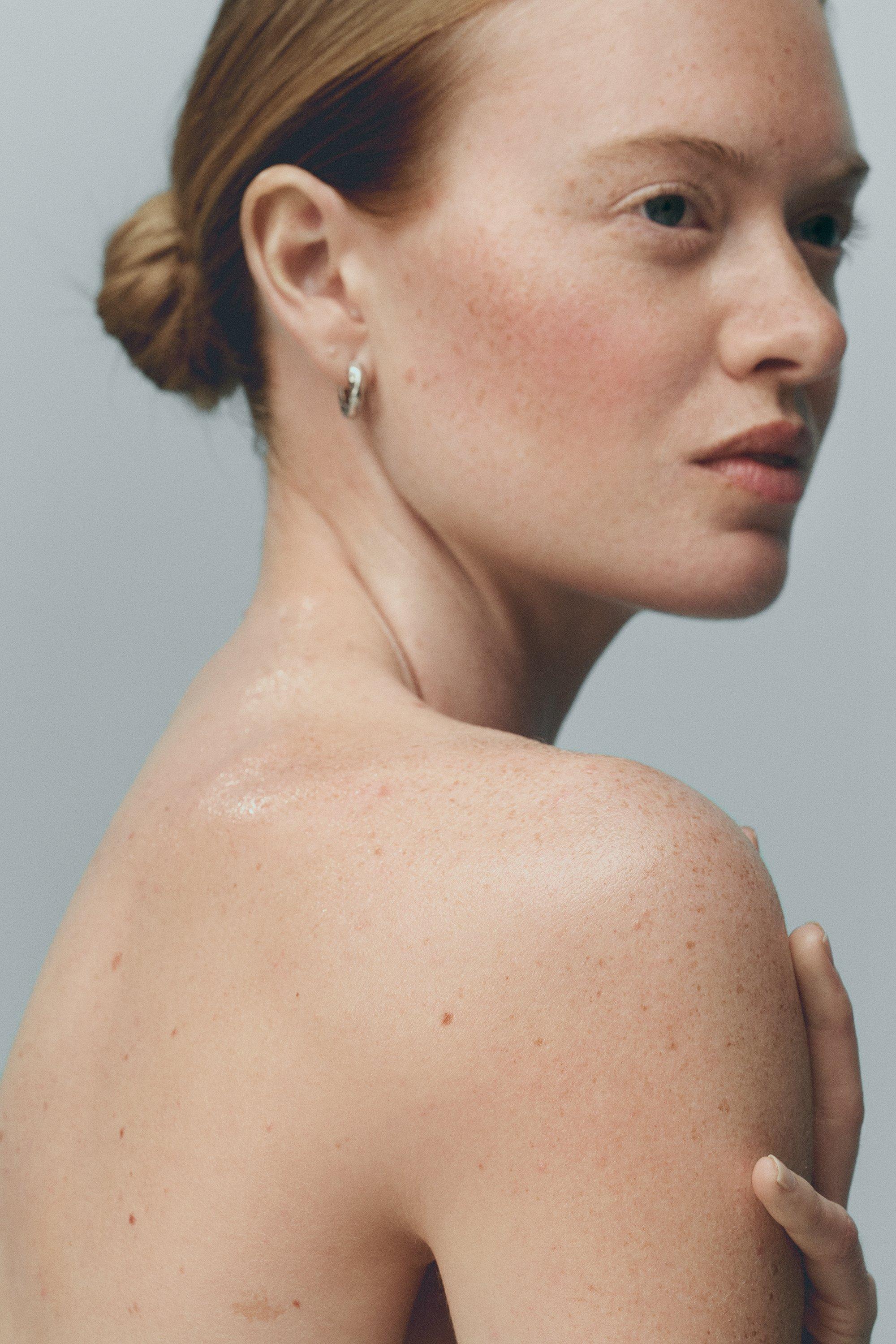 Kvinna smörjer in ansiktet med kräm