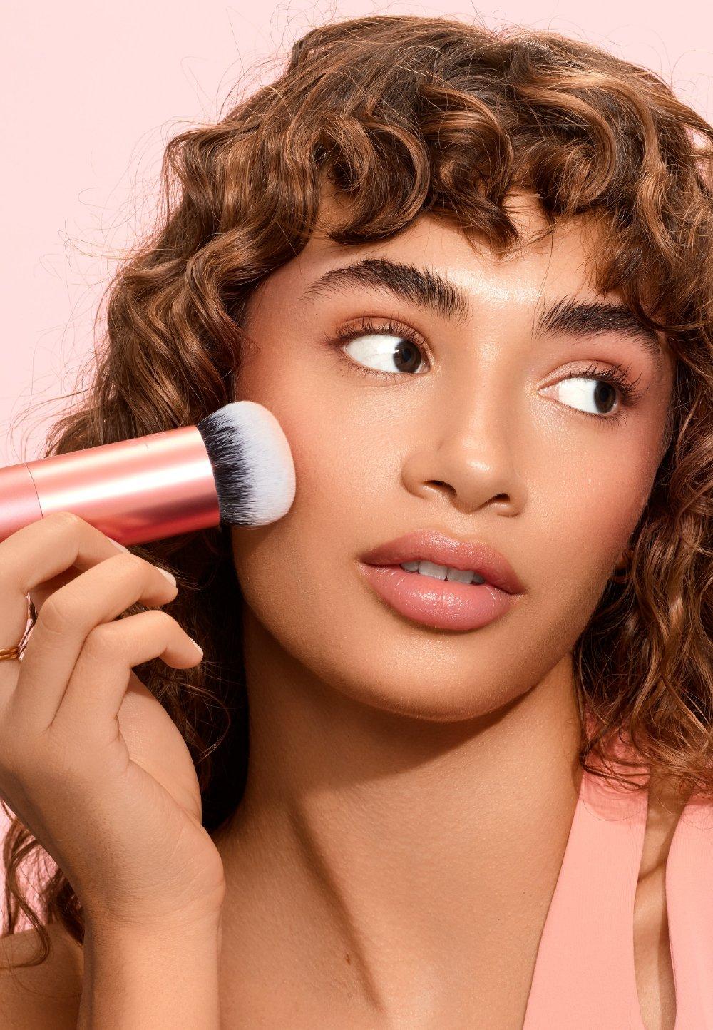 Tjej sminkar sig med en sminkborste