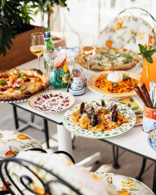 Italienska rätter och pizza serverade på dukat bord hos restaurang Basta.