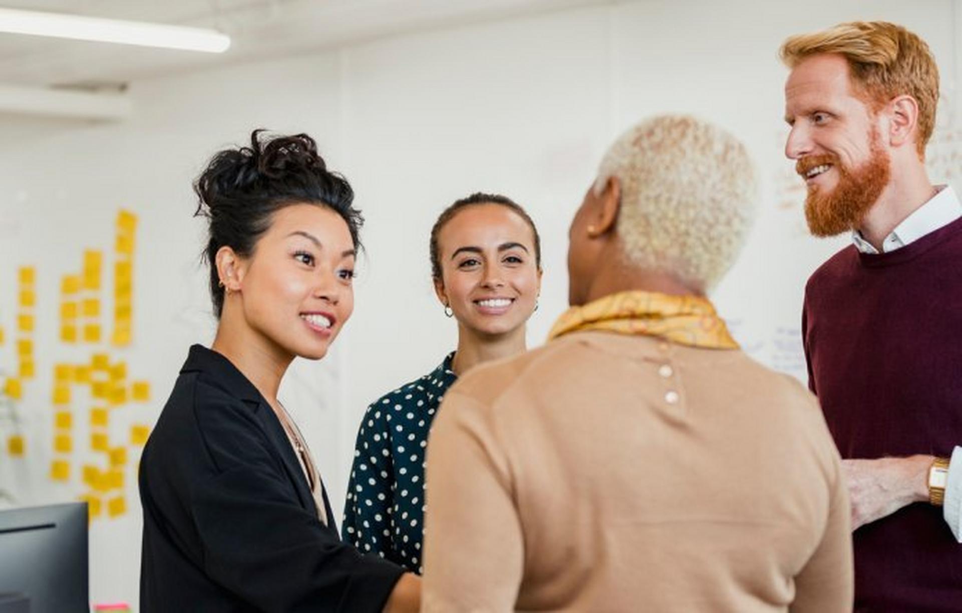 4 people having a conversation in a conference room