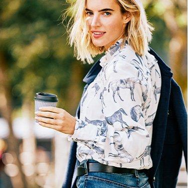 women in ariat shirt holding coffee cup