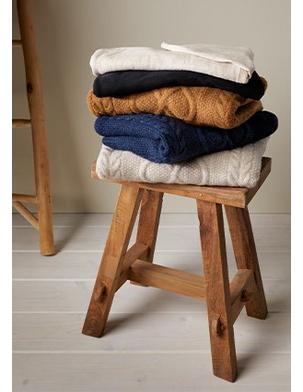 stack of sweaters in fall colors on stool