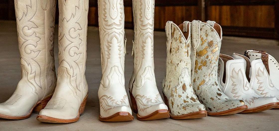 white western boots lined up along a wooden wall