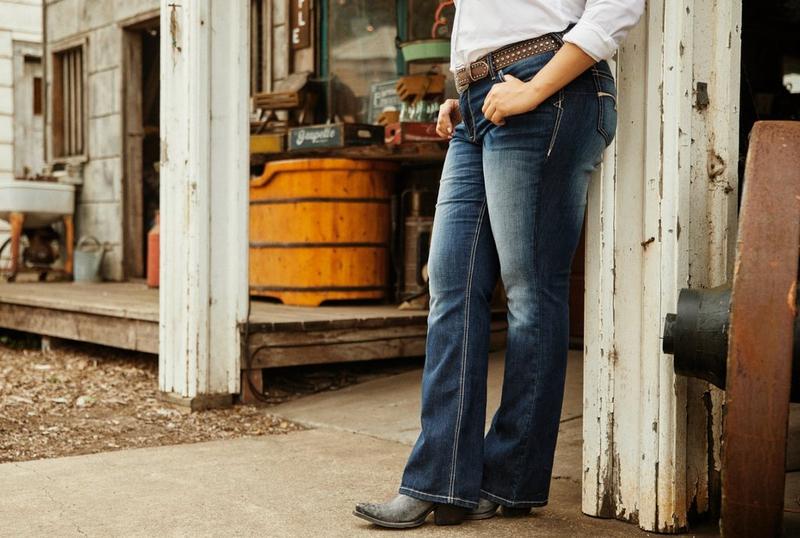 Woman standing next to Barn in Ariat Jeans