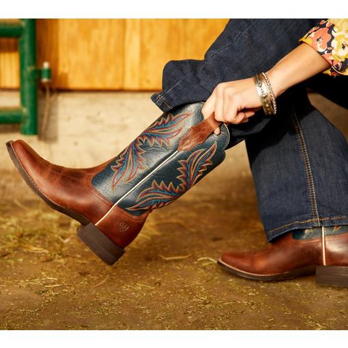 someone people on ariat western boot in barn