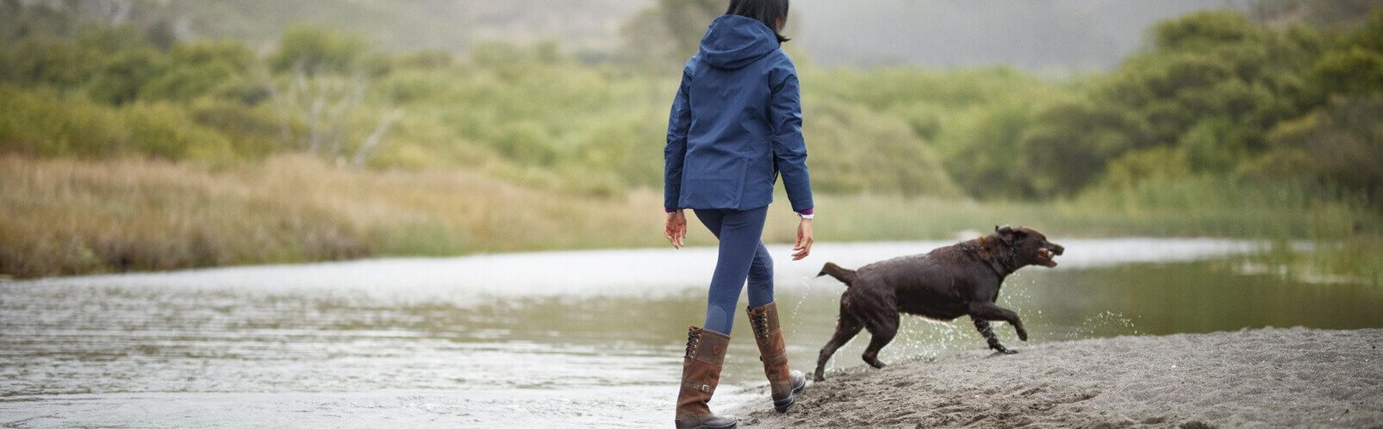 woman walking in water with dog